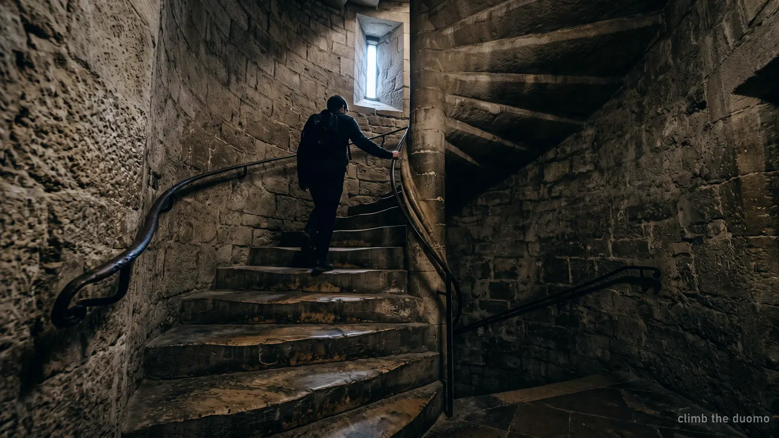 The narrow spiral stone staircase climbed to reach the Duomo Milan terraces, worn marble treads curving upward