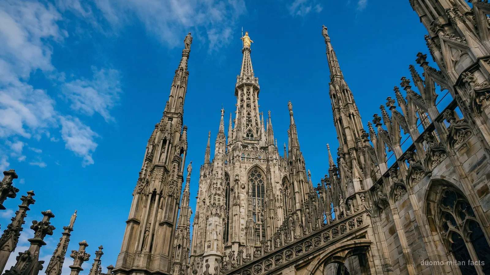 Looking up the main spire of the Duomo di Milano towards the gilded Madonnina at its summit