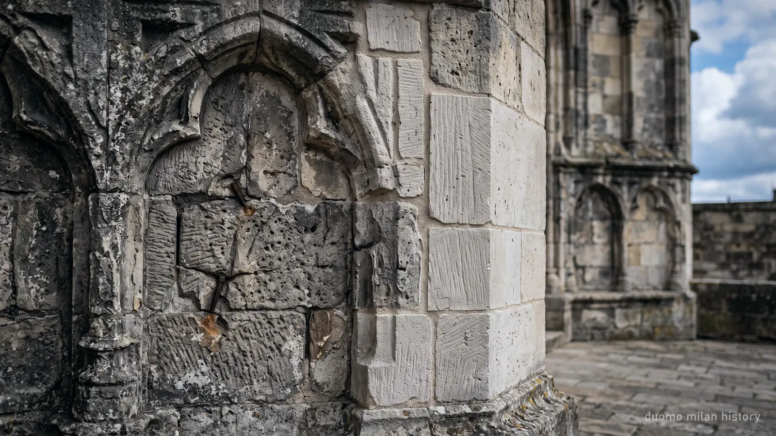 Weathered and newly replaced marble blocks side by side on the Duomo di Milano, showing centuries of repair