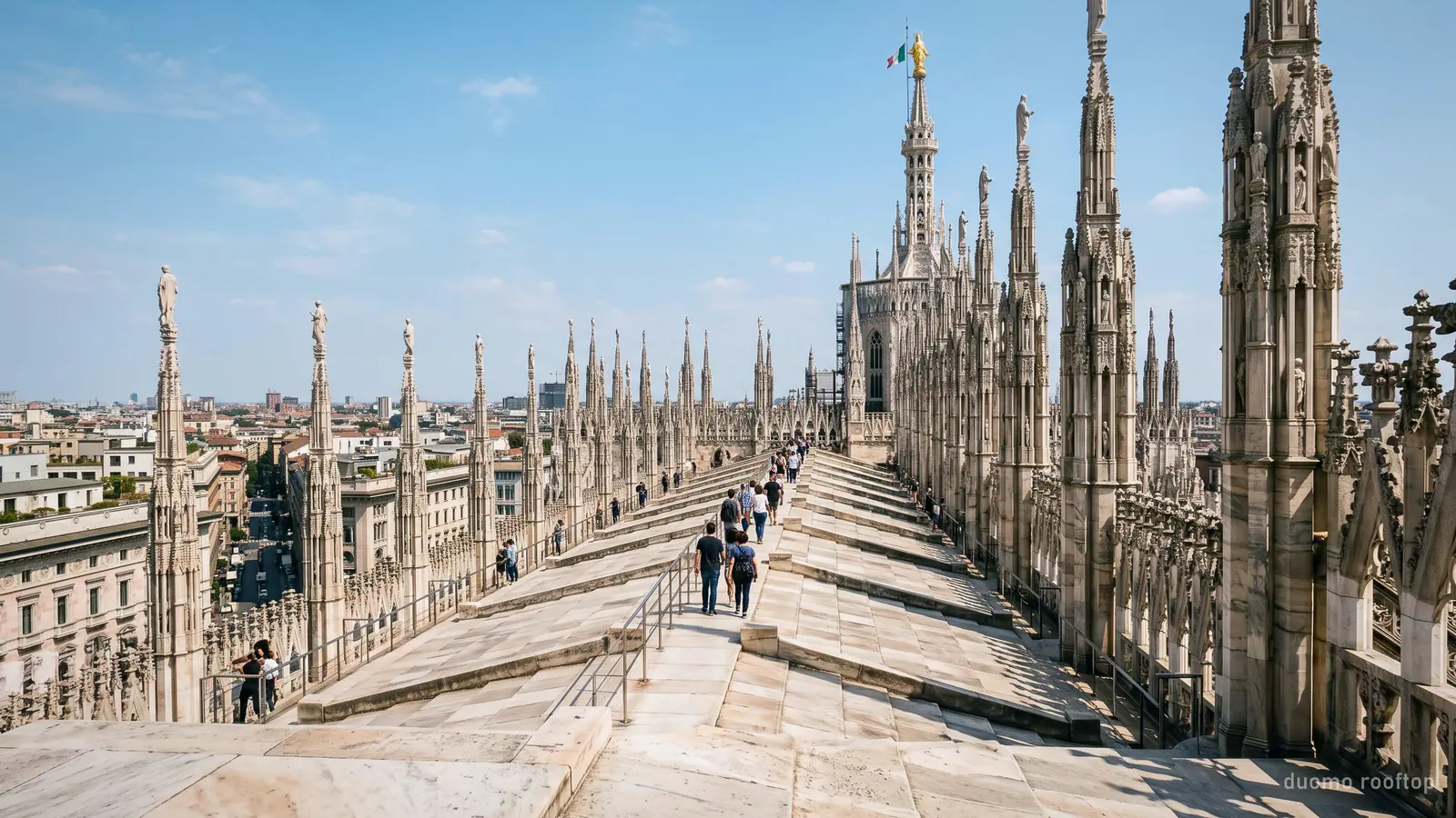 The Duomo Milan rooftop terraces: a marble walkway threading between carved spires towards the main spire