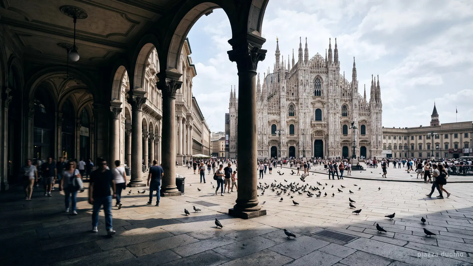 Piazza del Duomo in Milan framed by the arcade columns on the north side, the cathedral facade at the far end